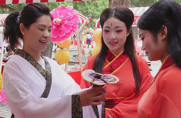 芝人堂联合创始人、执行总裁陶磊（左一）向游客介绍灵芝文化